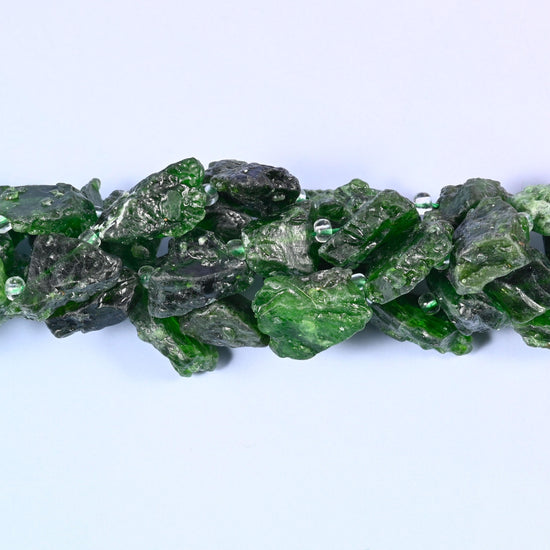 Deep forest green nuggets straight off the rock — rough unpolished faces with pale mint and white breaking through the darker stone