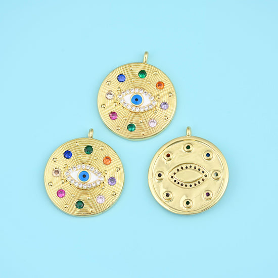 A large round medallion with a textured hammered face, an eye motif set at the centre in white and blue zircon