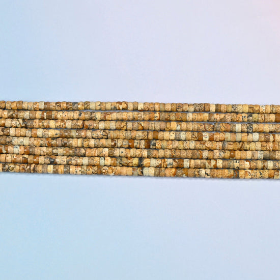 Several strands of picture jasper faceted heishi disc beads laid in straight rows
