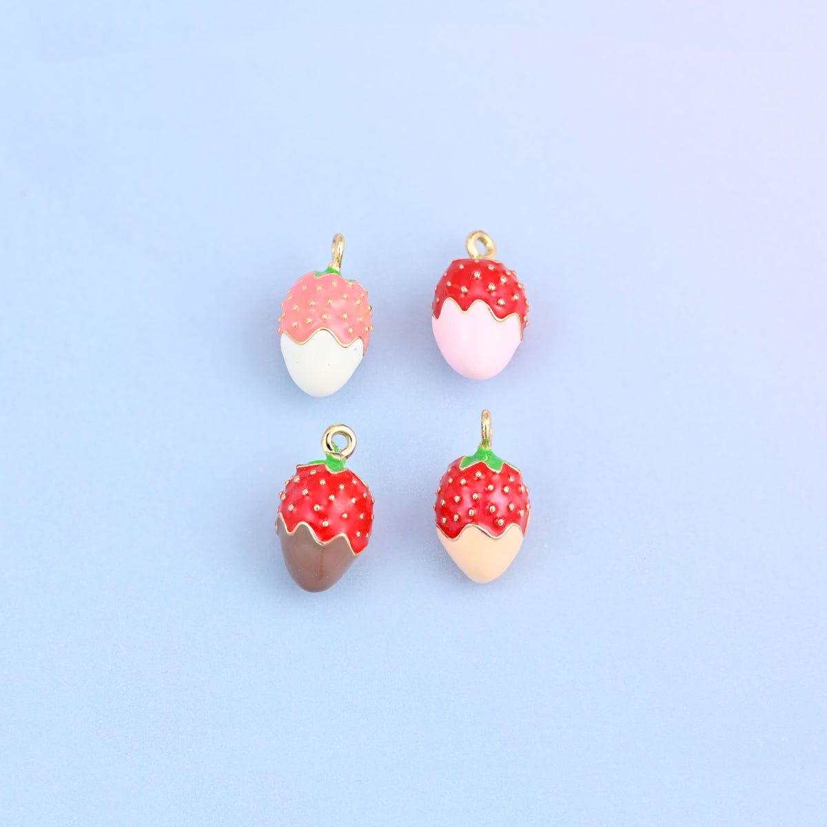 Four strawberry charms in two rows, one in each dip color.