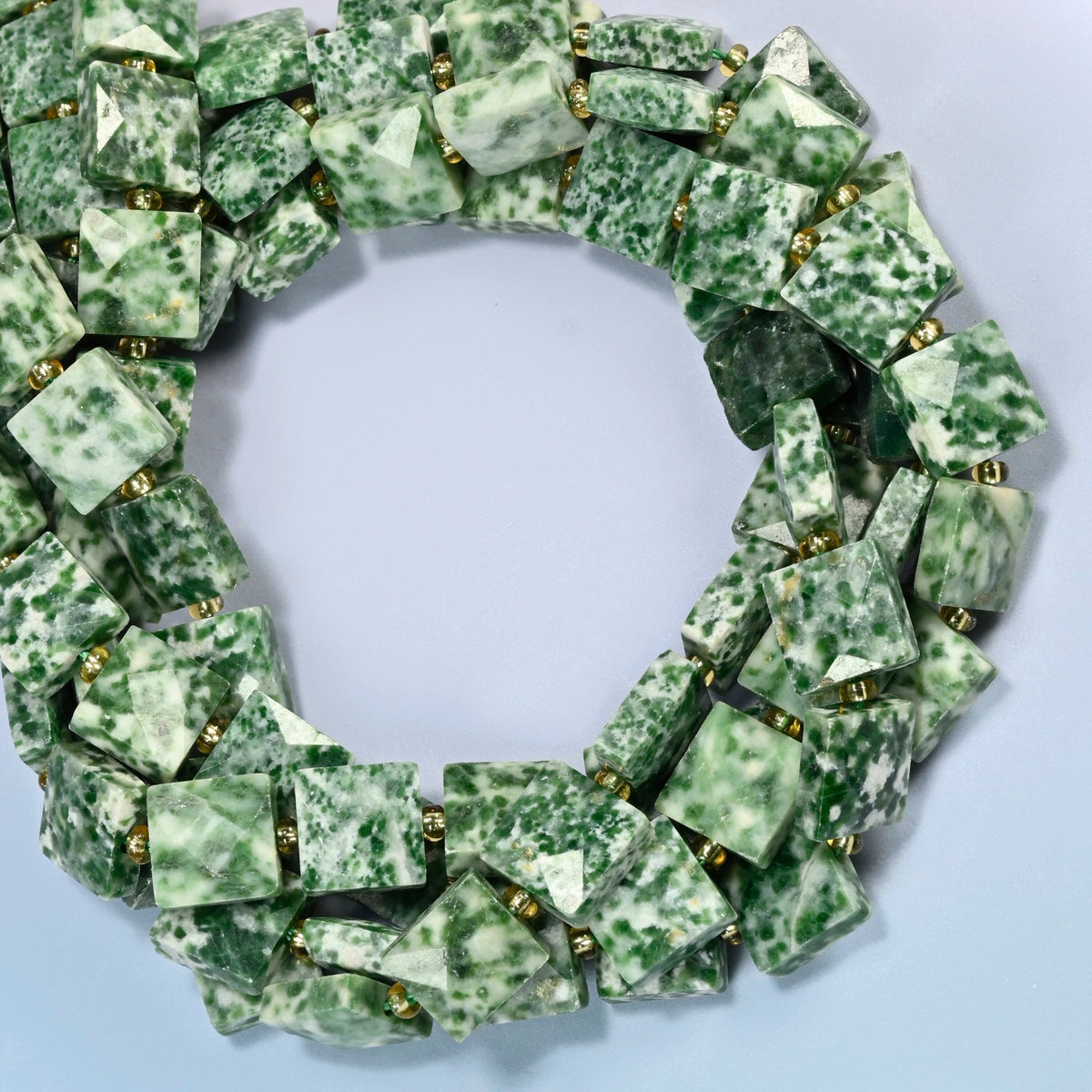 Tree agate faceted flat square beads coiled into overlapping loops, whole strands of green-spotted white stone