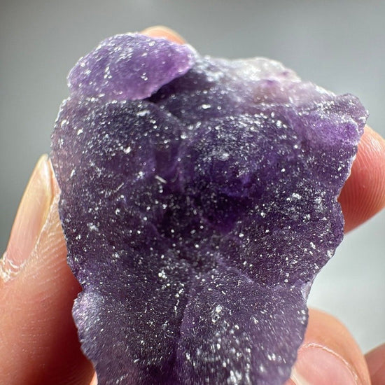Close view where sparkling white grains sit scattered across the violet surface