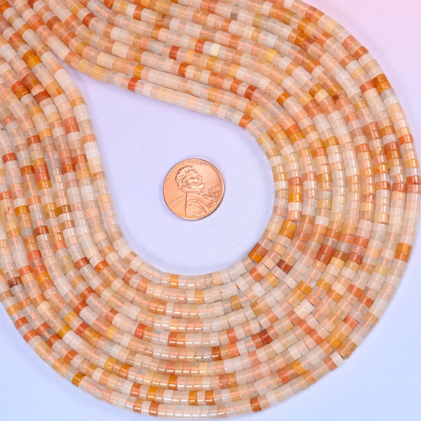 Natural Pink Aventurine smooth heishi disc beads in warm peachy-cream tones with soft coral accents, finished with a polished, sophisticated look.