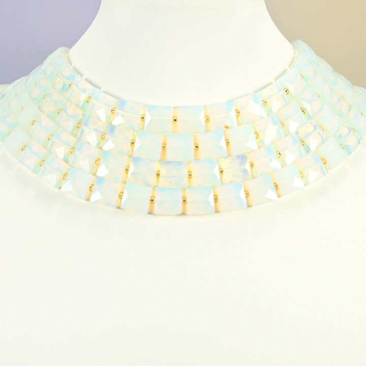 Opalite faceted flat square strands arranged as a layered collar on a white display bust, milky white beads across the neck