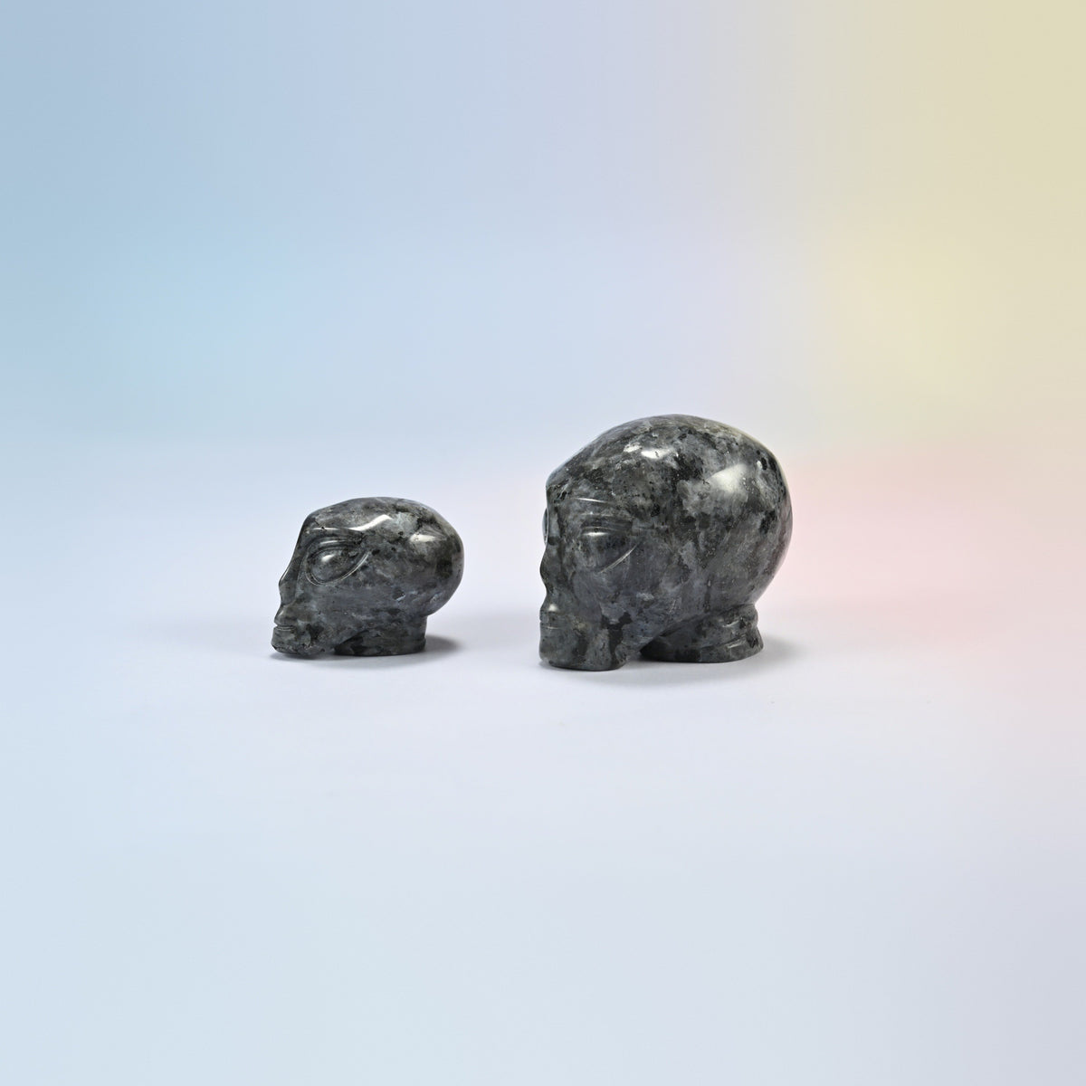 Two black labradorite alien head crystal carvings, 1.5 inch and 2 inch, dark gray natural stone with light flecks