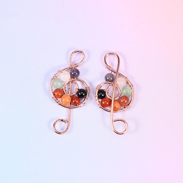 Rose gold wire version of the Treble Clef Music Symbol Pendant, a close-up pair filling the frame so the bound bead cluster and the curled tail read clearly.