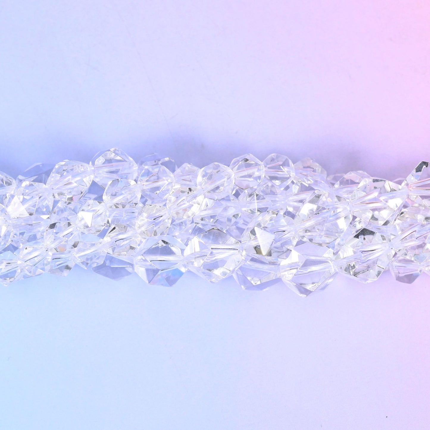 Clear Quartz diamond star cut beads, a single strand laid straight, star faceted all round