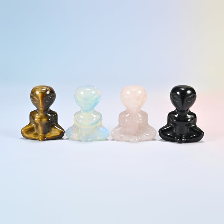 Four 1.5 inch yoga alien crystal carvings in natural tiger eye, opalite, natural rose quartz and natural black obsidian, sitting cross-legged