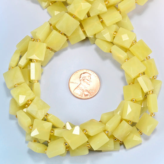 Lemon Jade faceted flat square beads 10x10mm coiled in a loop around a US penny for scale, close-up of the faceted flat square shape