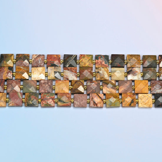 Several strands of natural red howlite faceted flat square beads laid in straight rows