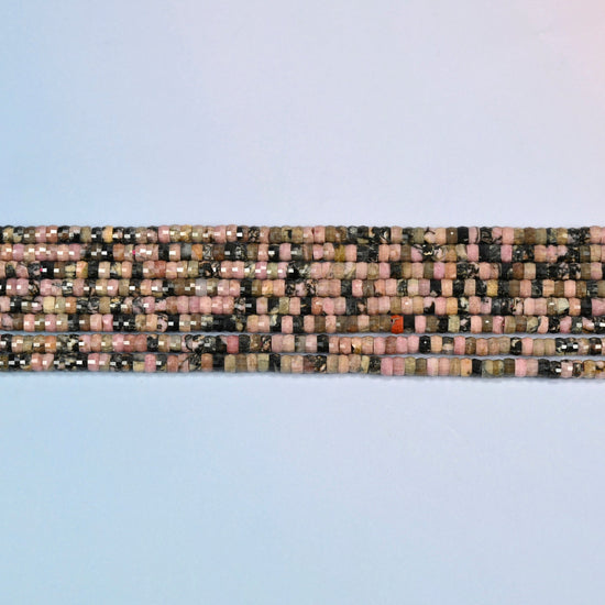 Several strands of rhodonite faceted heishi disc beads laid in straight rows