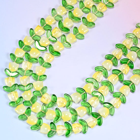 Circular coil of yellow tulip and green leaf glass bead strands forming a wreath shape on a lavender background.