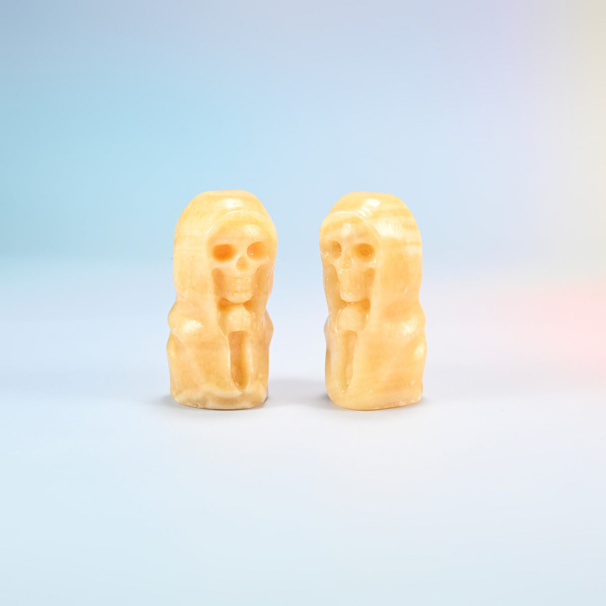 Two natural yellow jade hooded skull carvings in orange-yellow with soft banding, 2.5 inch