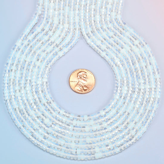 Opalite faceted heishi disc strands formed into a teardrop loop around a US penny for scale
