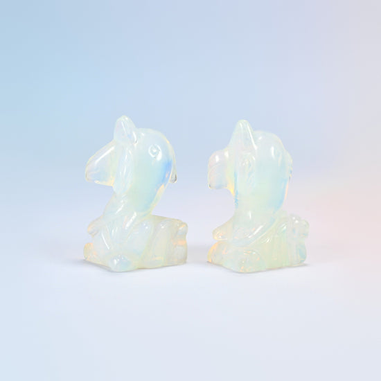 Two opalite dolphin on wave carvings facing each other