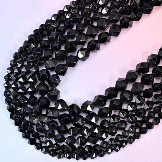 Black Onyx diamond star cut beads, strands crossing in a V, depth of black and surface lustre varying slightly bead to bead