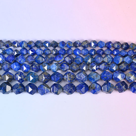 Blue Lapis Lazuli faceted beads in flat horizontal rows on a soft pink and lavender background, sold per 15.5 inch strand
