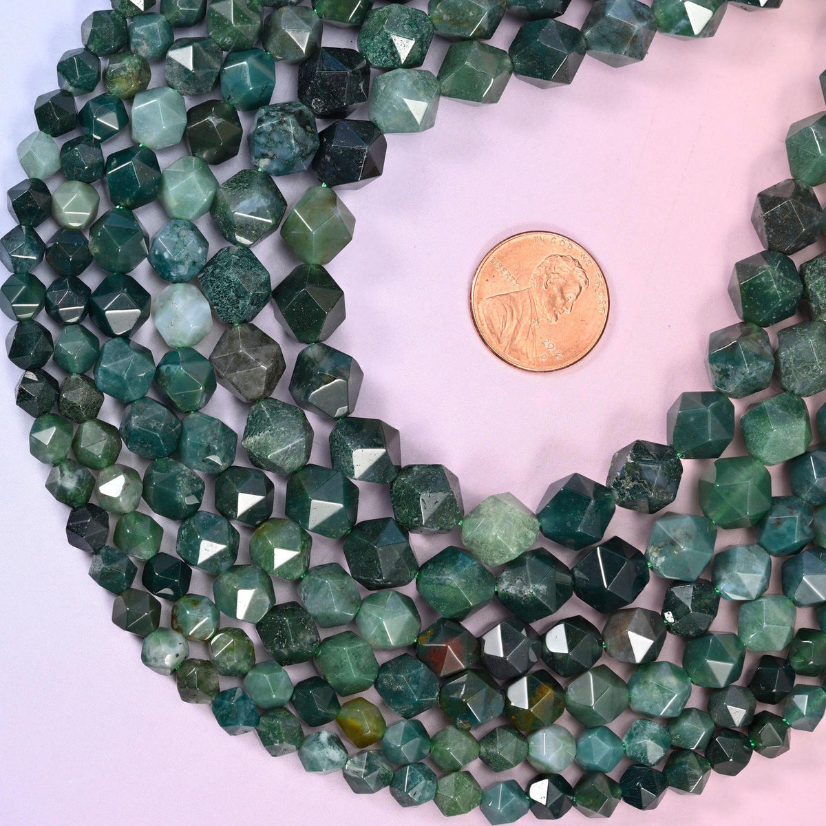 Moss Agate diamond star cut beads coiled around a US penny for size reference, centre drilled