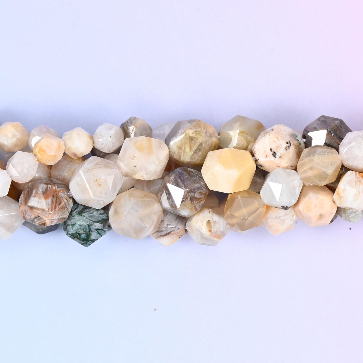 Pale cream, bone and soft grey stone flecked with tan, dark green and charcoal speckling