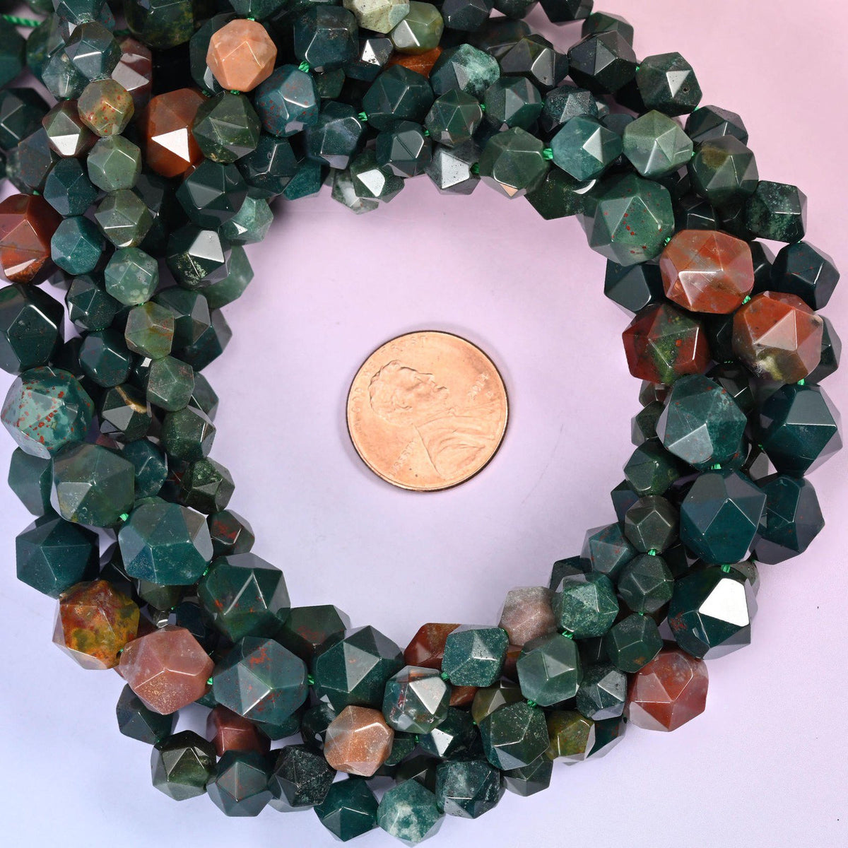 Indian Bloodstone beads coiled around a US penny, hole size approximately 1.0mm, deep green with red-brown flecking