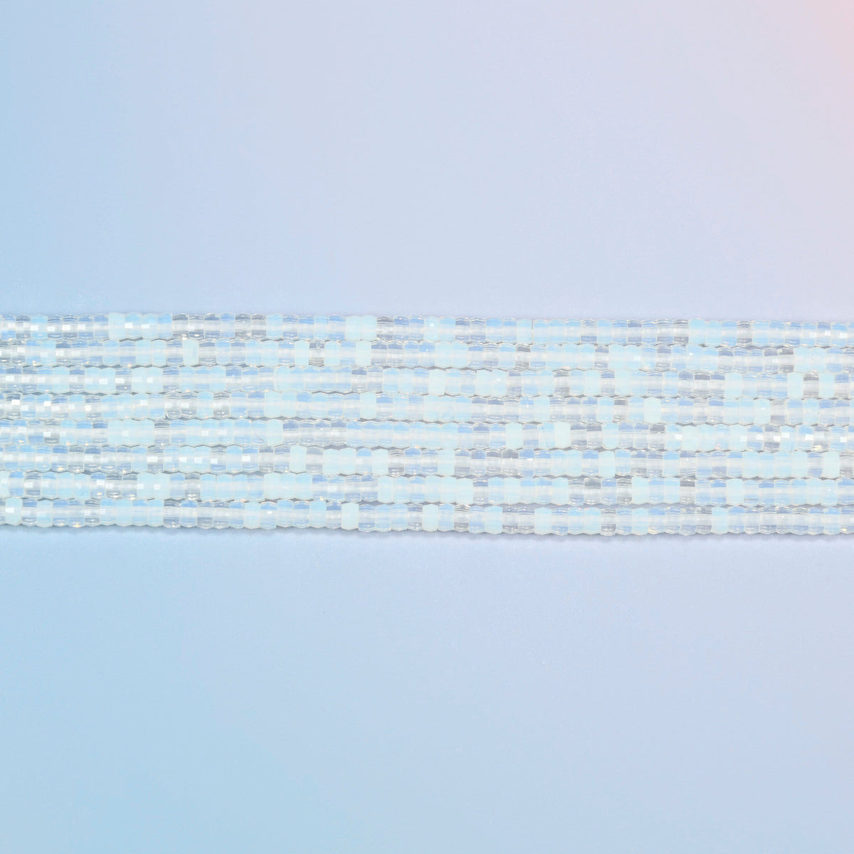 Several strands of opalite faceted heishi disc beads laid in straight rows