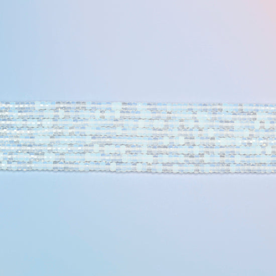 Several strands of opalite faceted heishi disc beads laid in straight rows