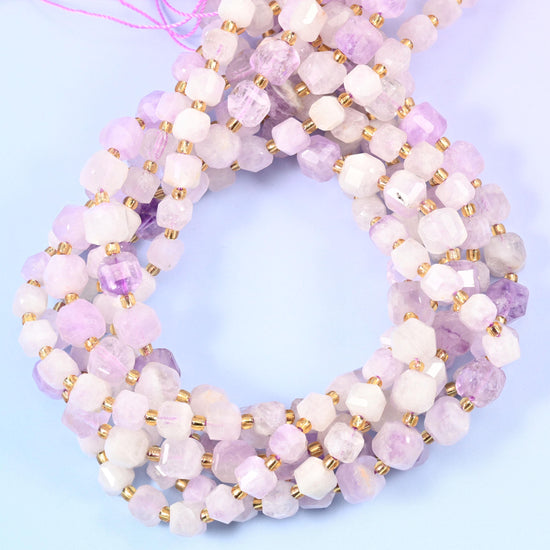 Creamy white stone washed with soft lilac and violet, some cubes almost pure milky white and others carrying a clear plum zone, cut flat-faced for a clean pastel finish.