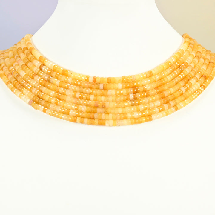 Gold Silk Jade faceted heishi disc strands arranged as a layered collar on a white display bust, golden yellow beads across the neck