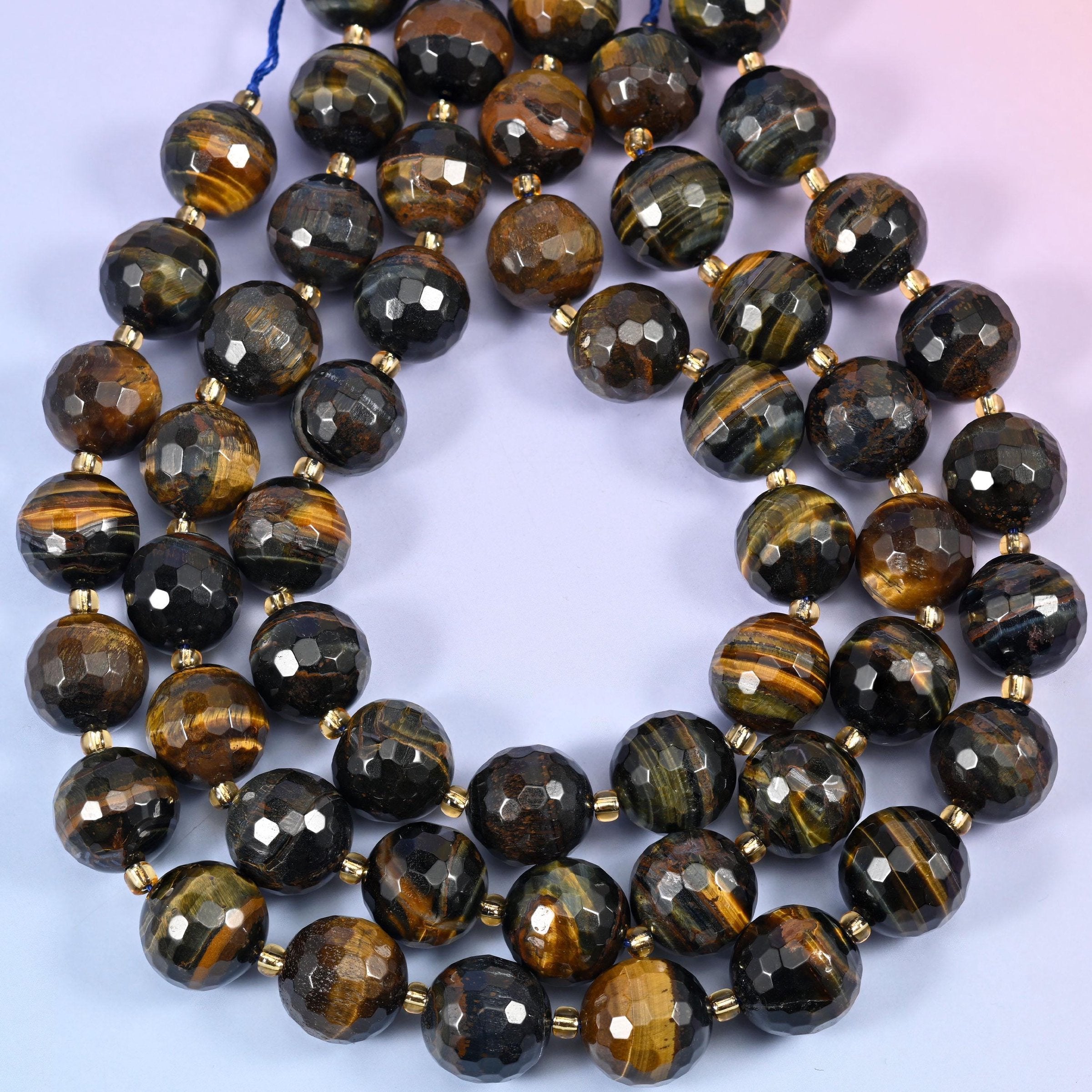 Big, heavy and richly banded, running through near-black steel grey, deep bronze and bright golden brown, with a chatoyant sheen sweeping across the facets.