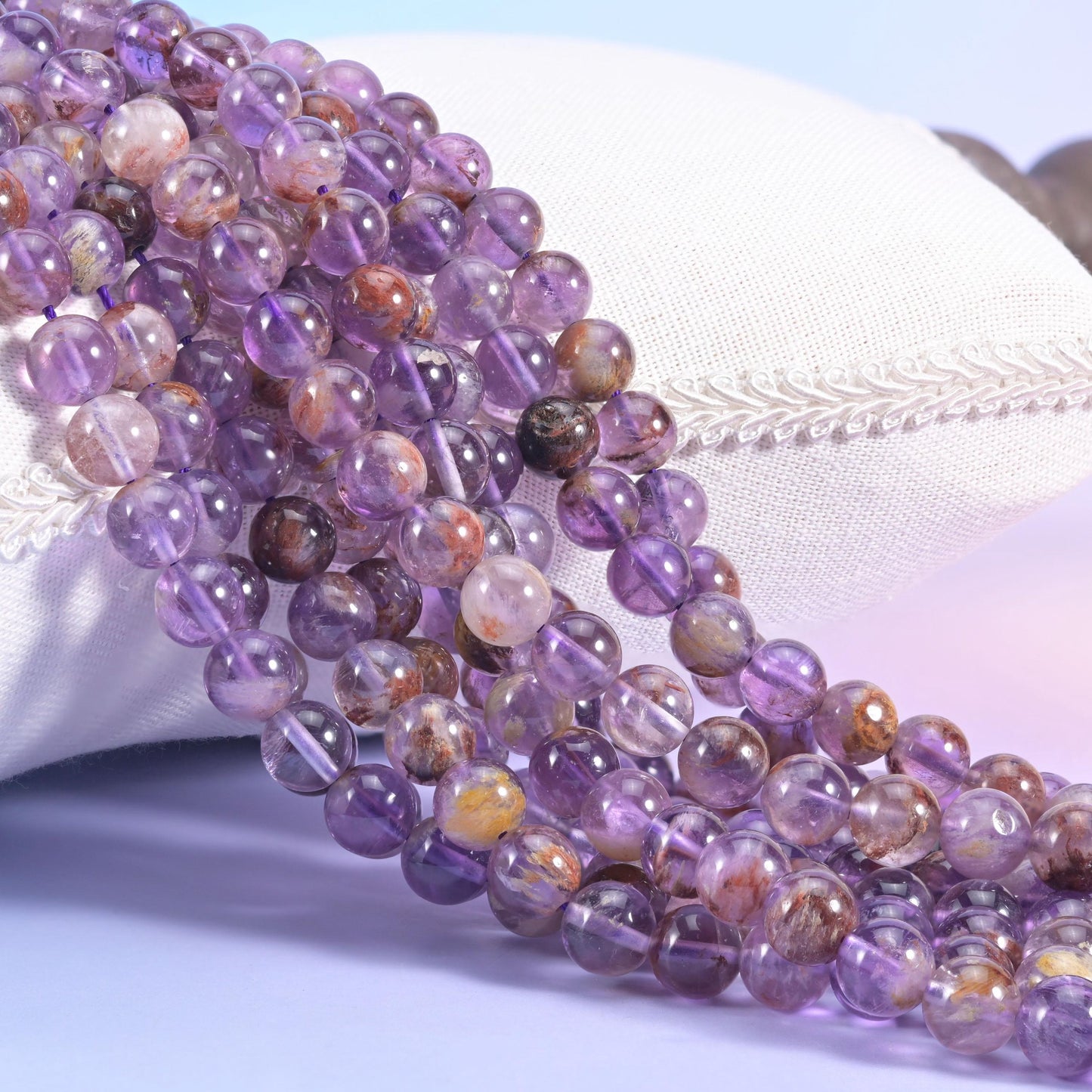Super 7 Purple Phantom Smooth Round Beads, translucent lilac-to-grape quartz with rust-brown inclusions