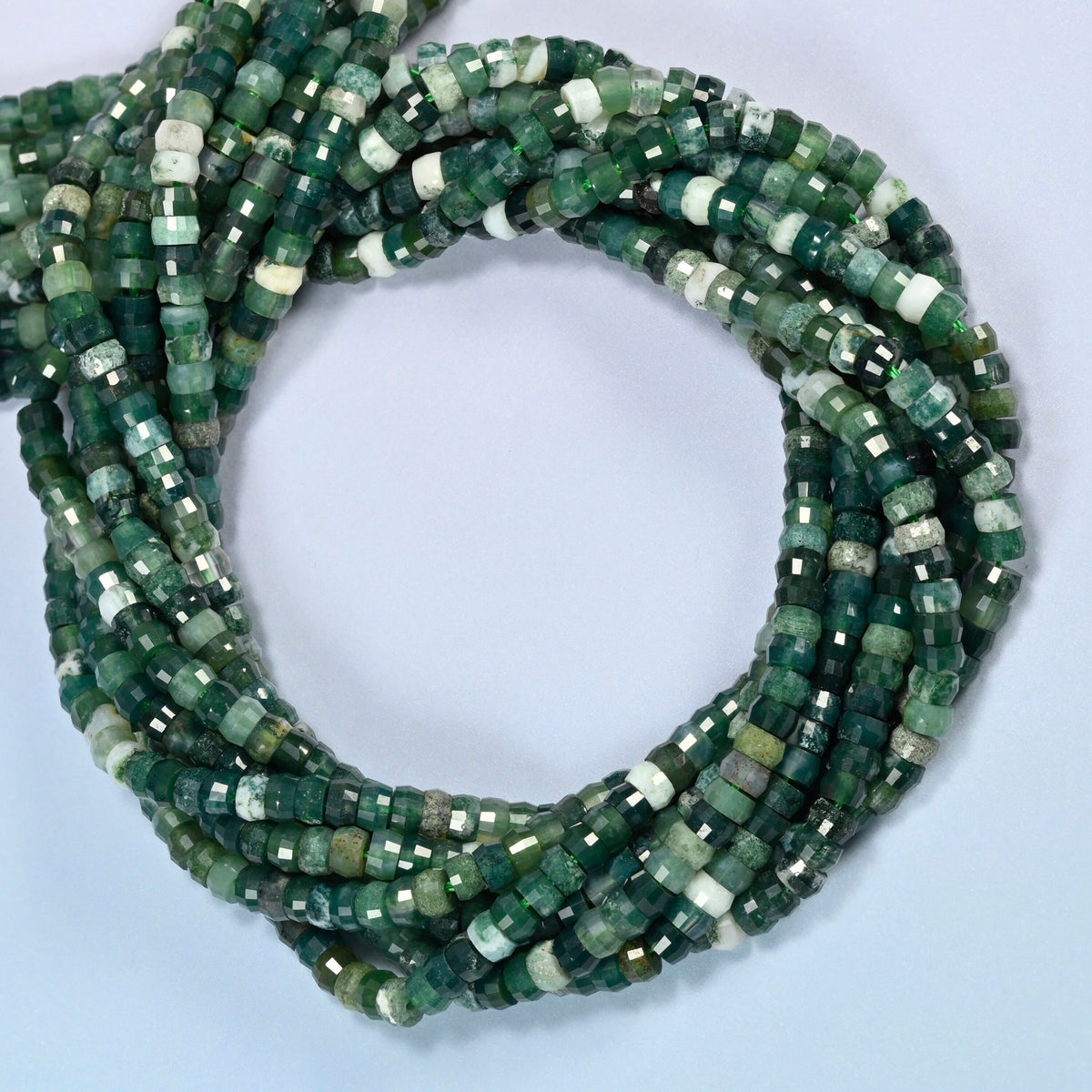Moss agate faceted heishi disc beads coiled into overlapping loops, whole strands of deep green stone