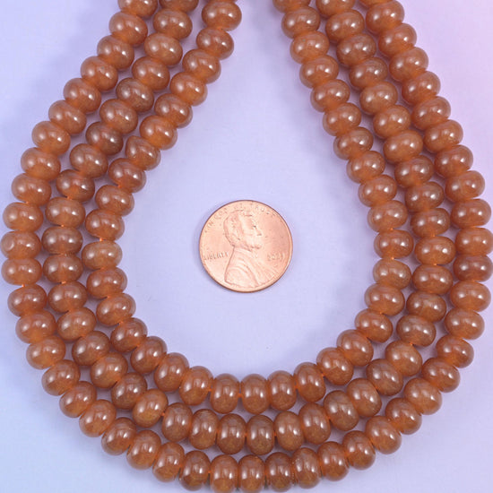 Caramel Dyed Jade smooth rondelle beads in a warm, glossy amber-brown, finished with a smooth, polished surface