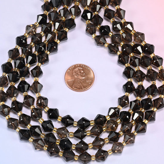 Close-up of 8mm Smoky Quartz faceted bicone beads coiled into a circle, showing the depth of the translucent smoky brown-gray tone.