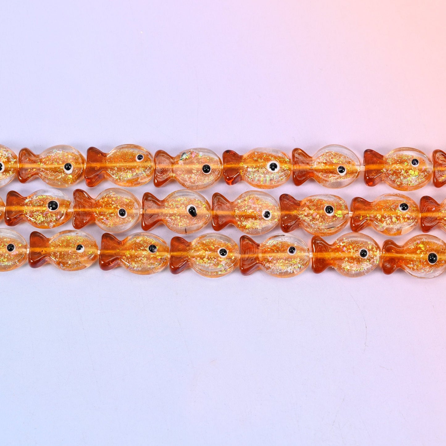 Orange Glitter Fish Glass Beads in warm amber orange with gold glitter