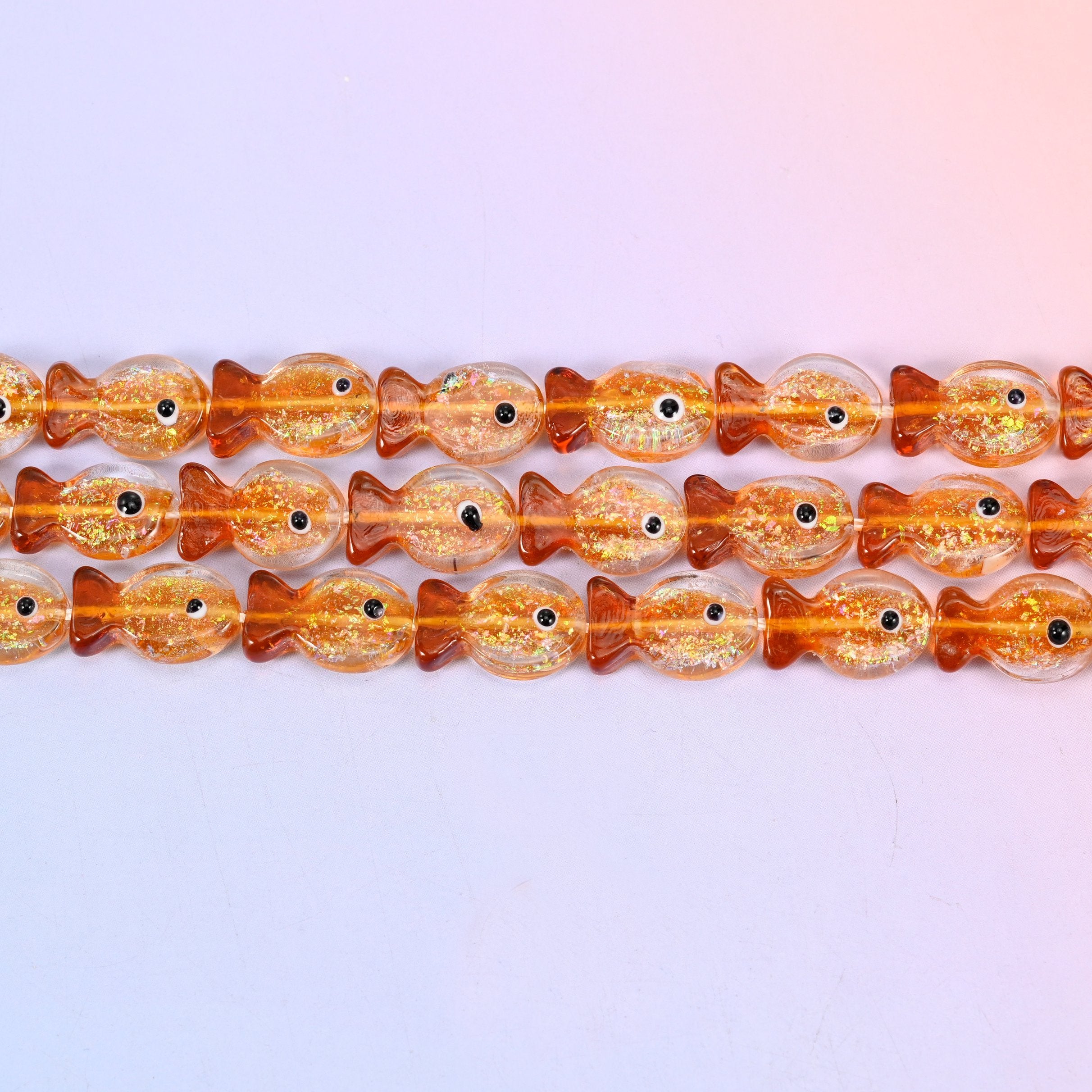 Orange Glitter Fish Glass Beads in warm amber orange with gold glitter