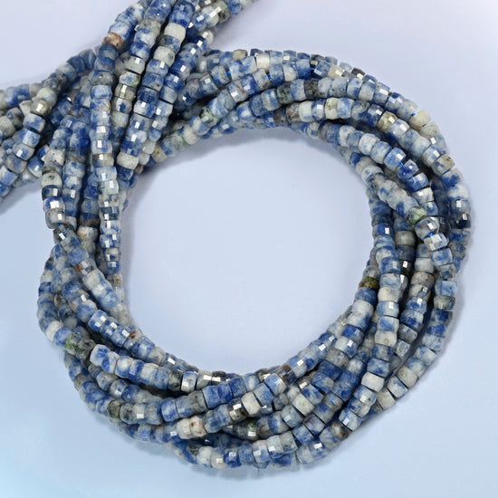 Blue spot jasper faceted heishi disc beads coiled into overlapping loops, whole strands of speckled blue and white stone