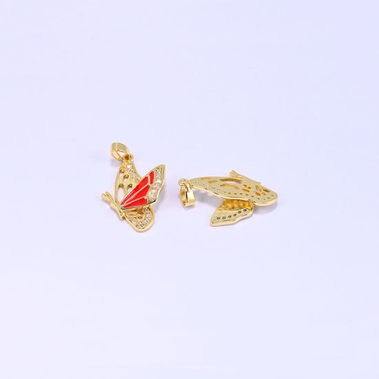 Flying butterfly charm pendant standing upright beside a second piece lying flat on its back, revealing the plain gold underside and cut out wing panels.