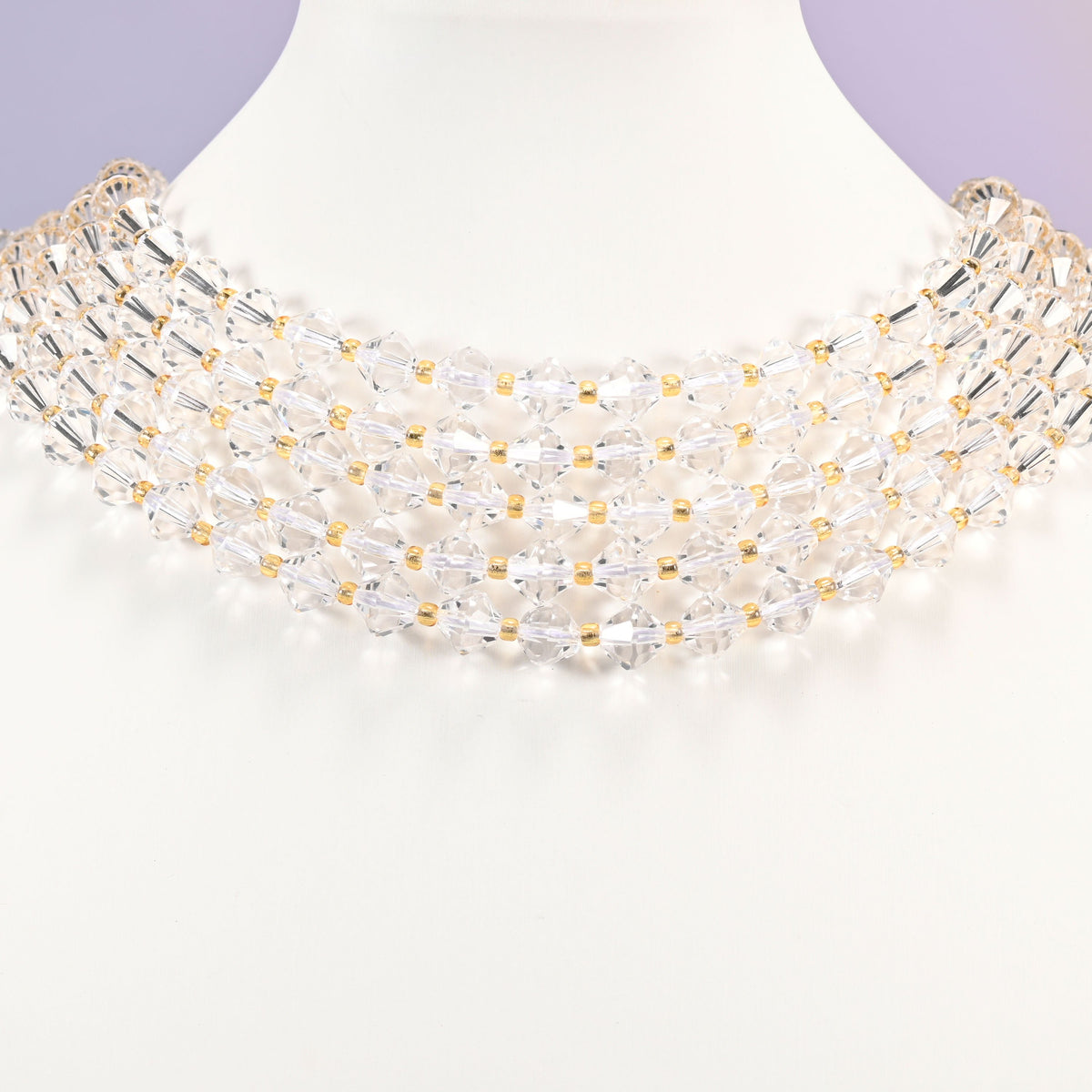 Strand of 8mm Clear Quartz faceted bicone beads worn on a jewelry display bust, showing the necklace-length drape.