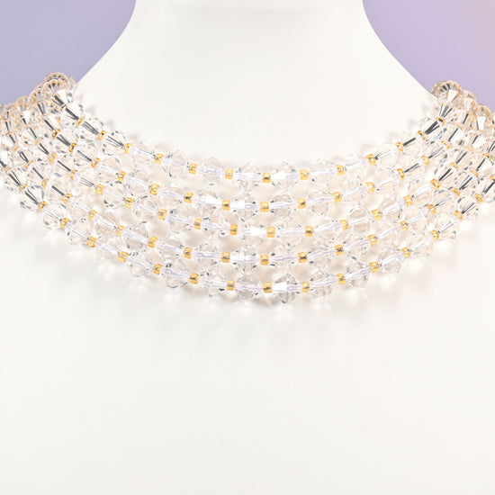Strand of 8mm Clear Quartz faceted bicone beads worn on a jewelry display bust, showing the necklace-length drape.