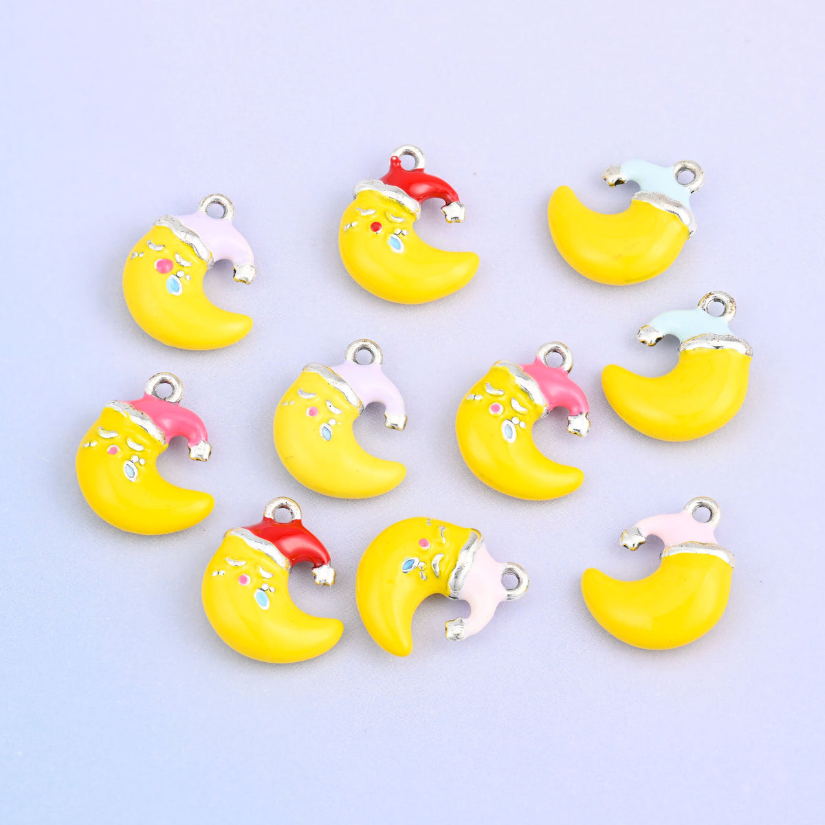 Eleven moon charms grouped together, showing all five Santa hat colors on the yellow crescent.