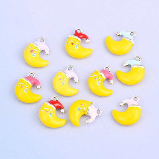 Eleven moon charms grouped together, showing all five Santa hat colors on the yellow crescent.