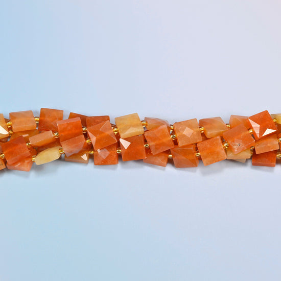 Strands of natural red aventurine faceted flat square beads twisted together in a horizontal row