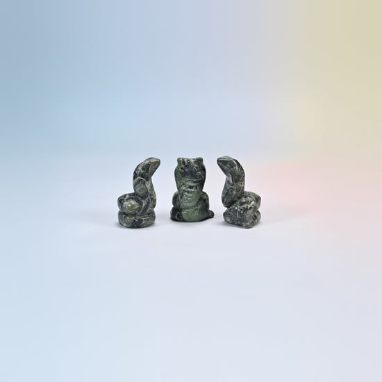Cobra snake crystal carving in kambaba jasper, dark green natural stone with black orb patterns