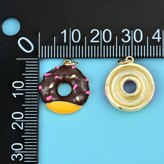 Sprinkle donut charm and its plain gold back on a millimetre ruler, showing size and thickness.