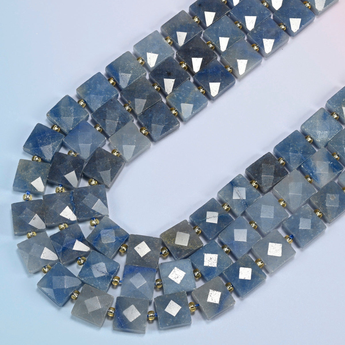 Natural blue aventurine faceted flat square beads in several strands curved into a wide U, denim blue stone with a fine shimmer