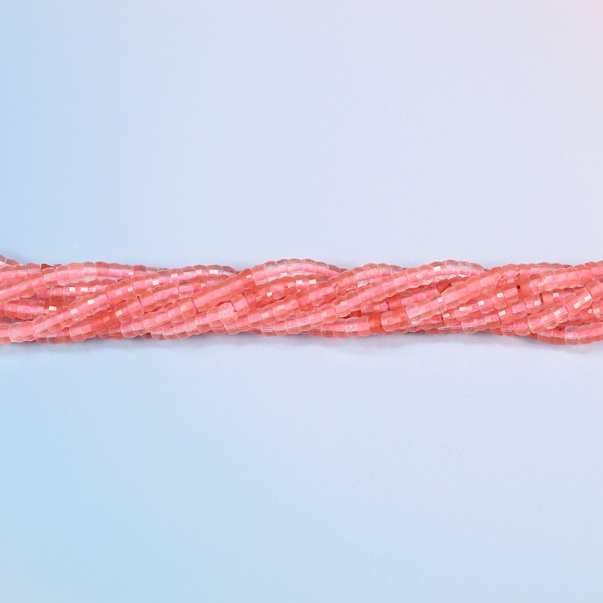 Strands of melon quartz faceted heishi disc beads twisted together in a horizontal row