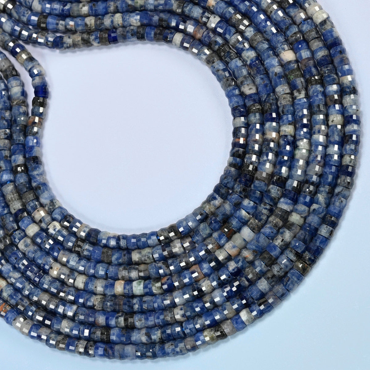 Sodalite faceted heishi disc beads curved into an open loop, deep blue beads with white and gray patches