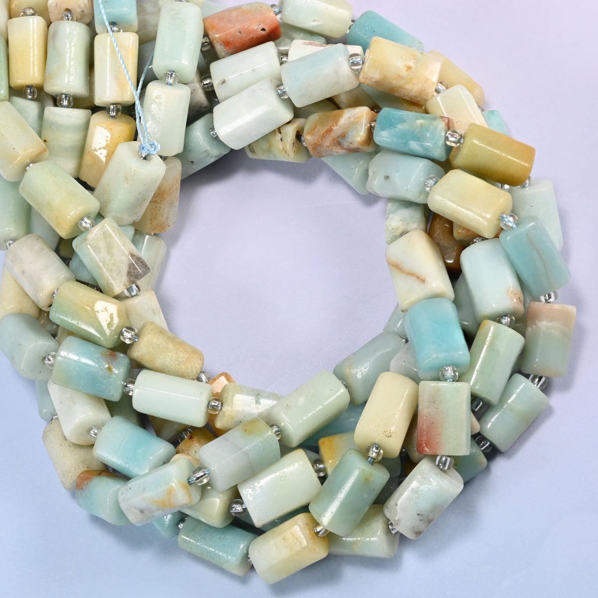 Multi-Color Amazonite faceted tube beads coiled into a ring, colour running from light blue and green to cream and yellow bead to bead