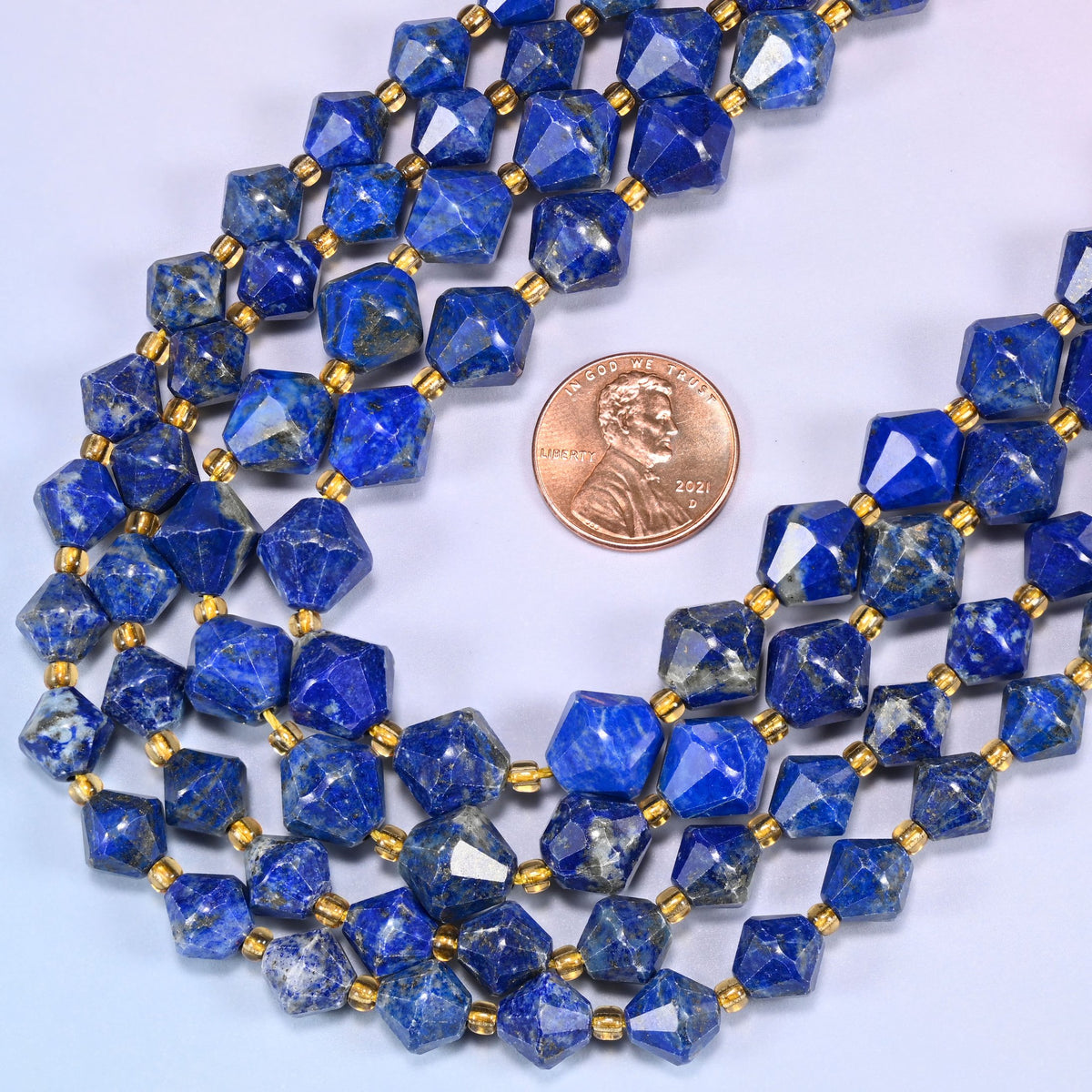 Lapis lazuli bicone beads in a wide curve, available in 8mm and 10mm, with a gold-tone spacer between each bead.