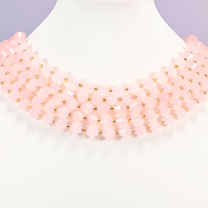 Rose Quartz bicone bead strand worn as a multi-strand choker on a display neck form.